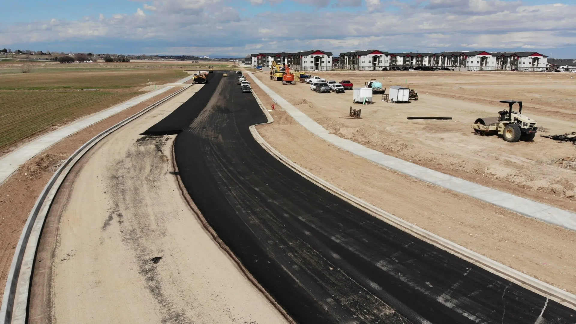 Wide aerial of the Discovery Meridian site in April 2023, with finished pads and paved roads laid out, ready for vertical construction