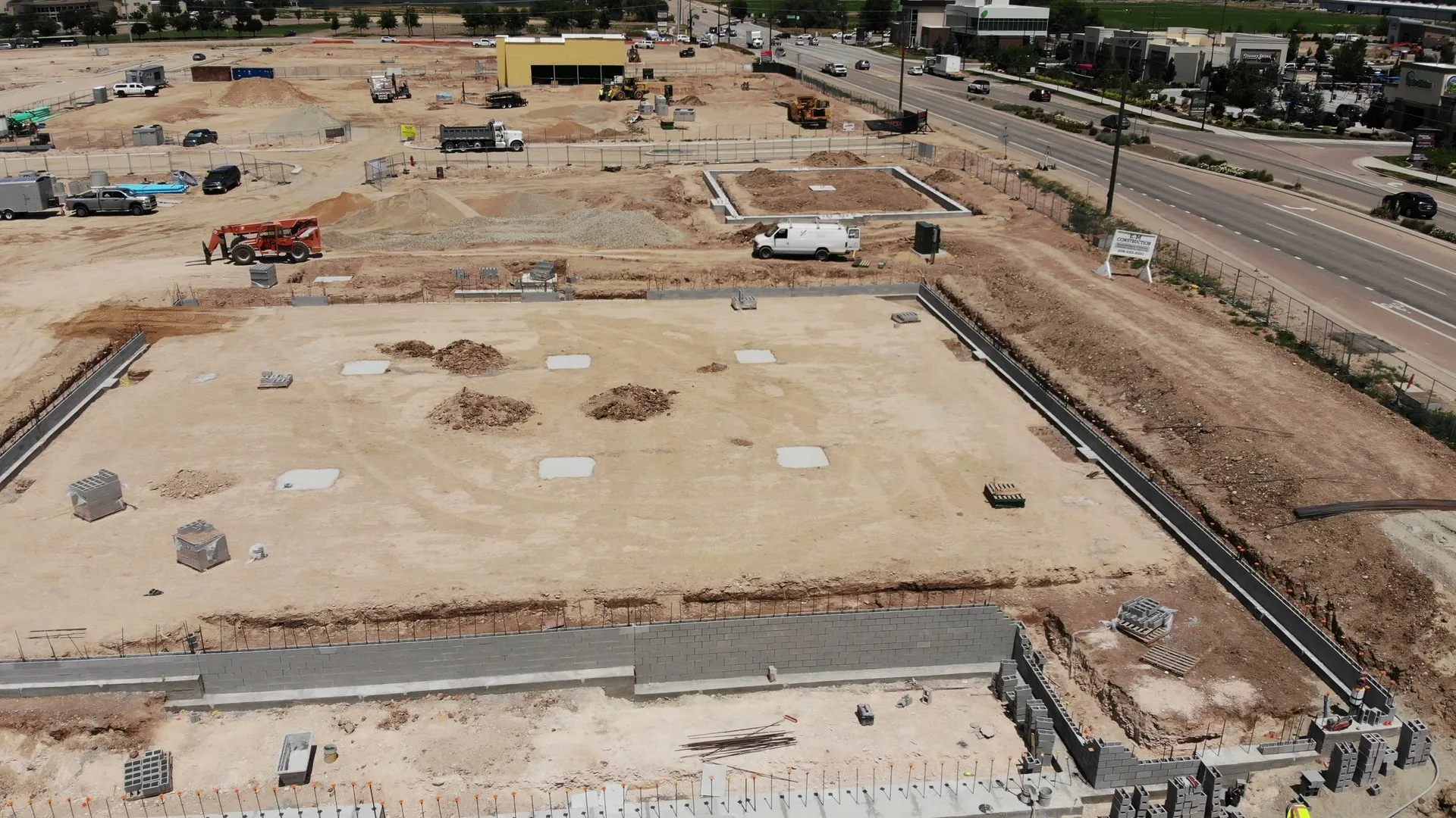 Aerial of the site in June 2023 with neighboring apartment buildings visible in the background, showing the broader neighborhood context
